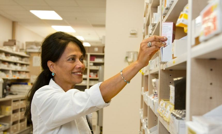 Pharmacist selecting a product from pharmacy inventory
